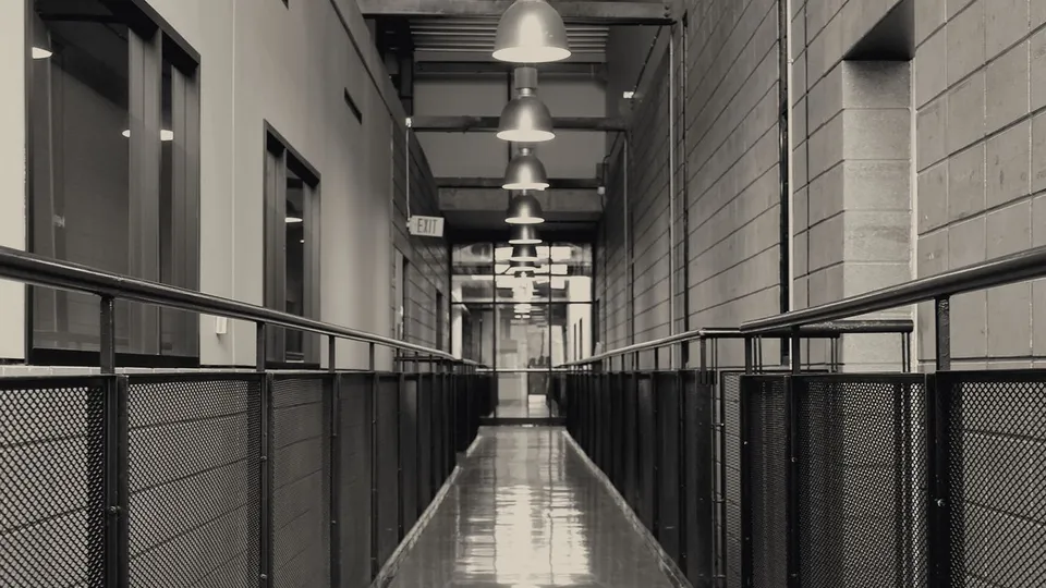 Industrial corridor with lighting and mesh railings